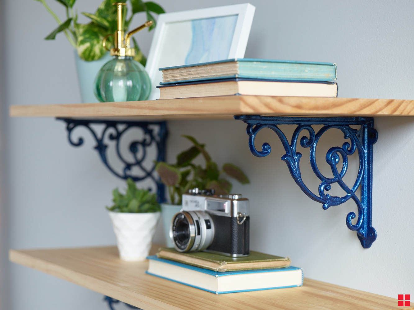 Metallic blue brackets holding up a wooden shelf.