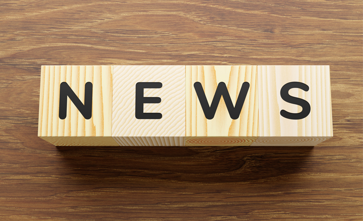 Four bare wooden blocks that spell the word "News" in black.
