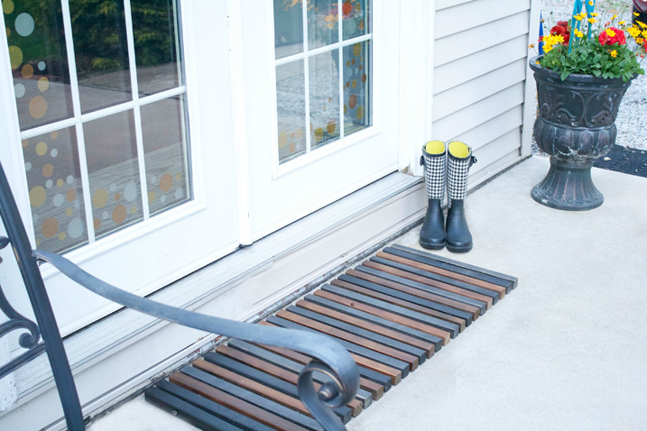stained skinny planks of wood tied together to become a door mat