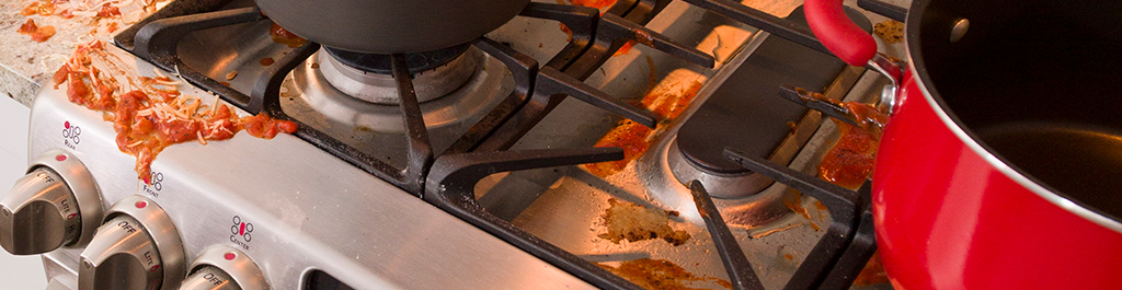 Spaghetti spilled on stovetop. 