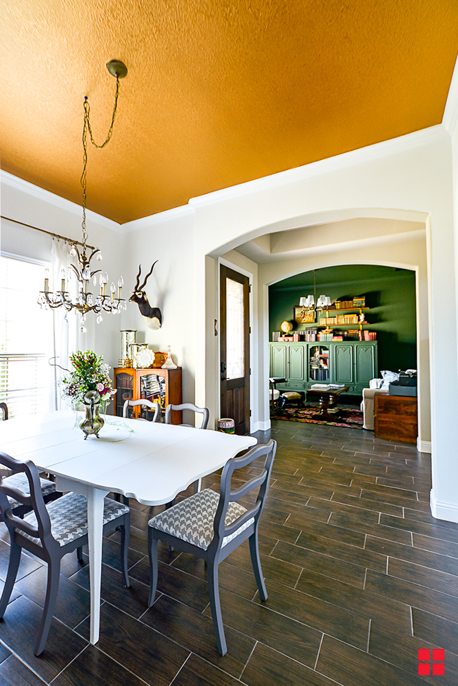 Dining room with white walls and a metallic gold ceiling. 