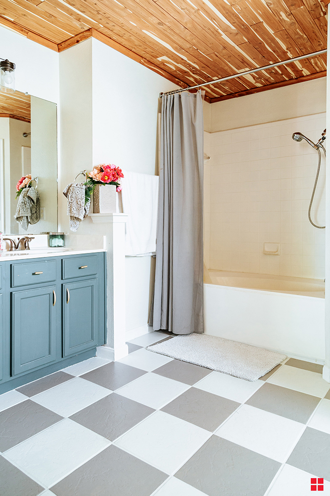  Bathroom with a blue vanity and white and gray checkerboard tile floor.