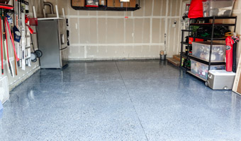 A garage floor with a shiny gray coating and black and white speckles. 