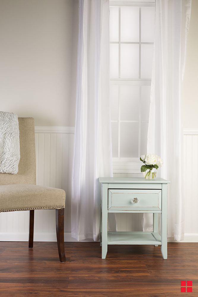 Pale blue end table with a flower vase on top.