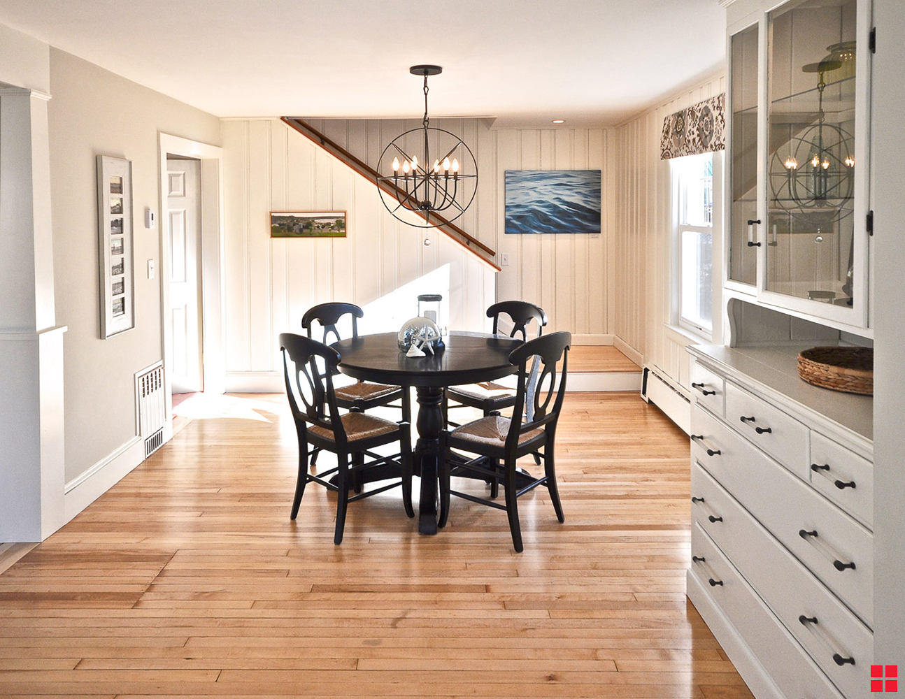 A dining table in a room with cream-colored painted paneling on the walls. 