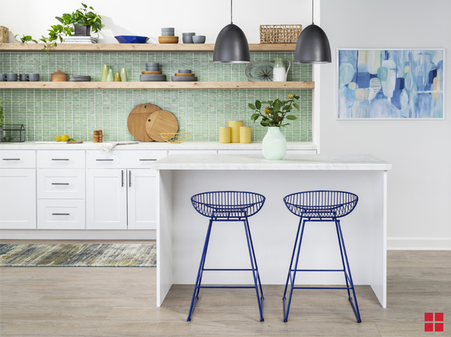 Two blue metal stools under a white kitchen island bar. 