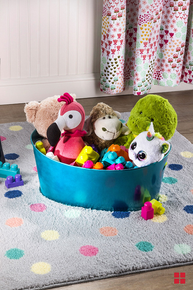 A blue metallic bin filled with stuffed animals and plastic blocks.
