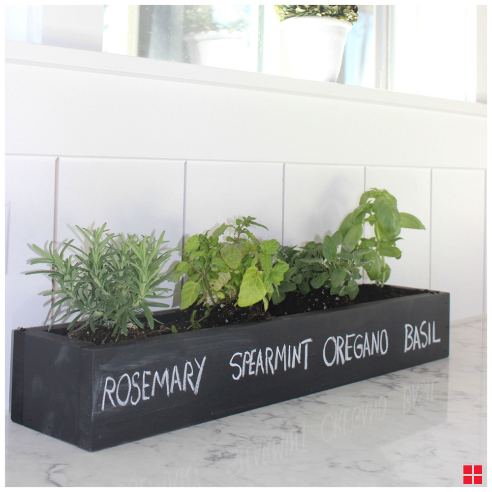 Planter with rosemary, spearmint, oregano and basil written in chalk.