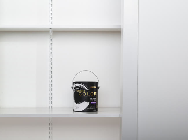 A can of white Studio Color Wall Paint on a closet shelf.