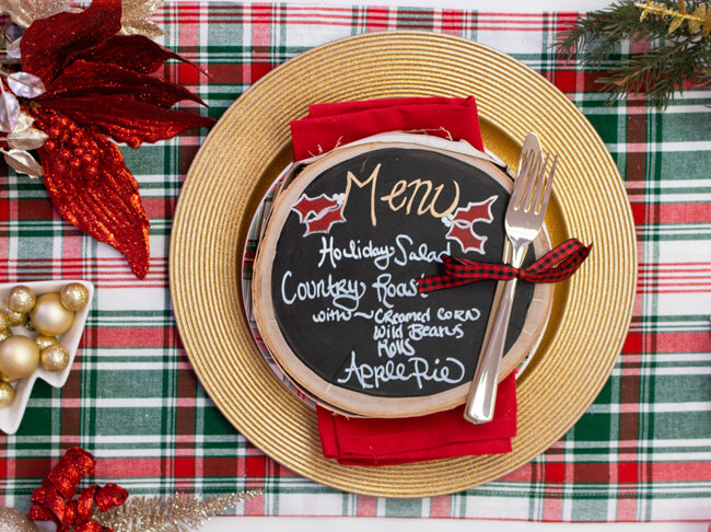 A chalkboard menu on top of a holiday place setting.