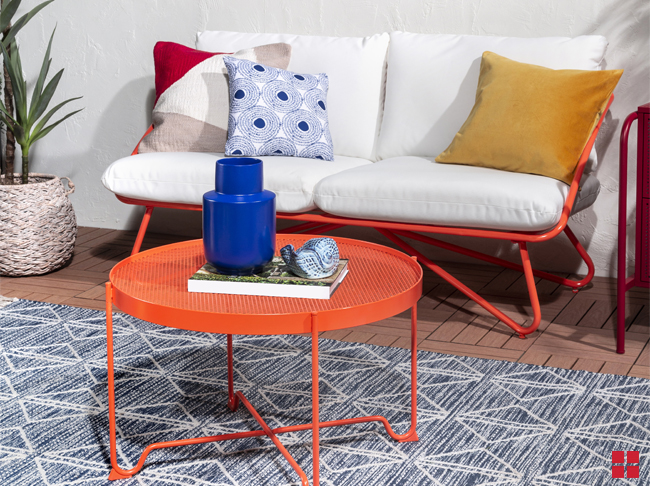 Orange patio table and cushioned bench with orange metal legs.