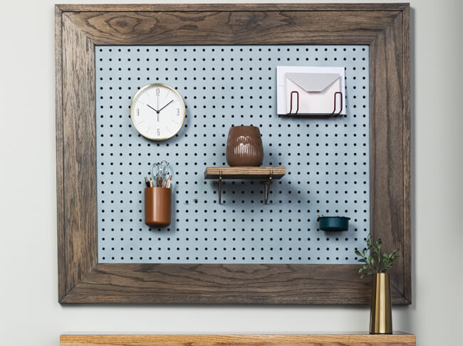 Finished Peg Board With Clock And Shelf Hanging On Wall