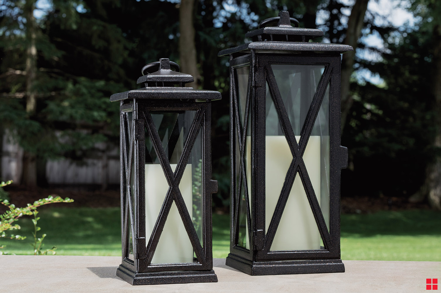 Two shiny black lanterns with unlit candles inside.