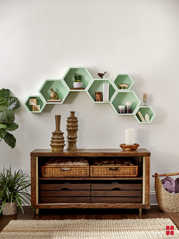 Seven hexagon shelves arranged over a living room buffet table. 