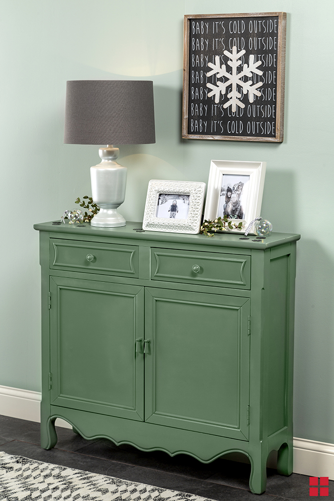Lamp and picture frames on an entryway table.