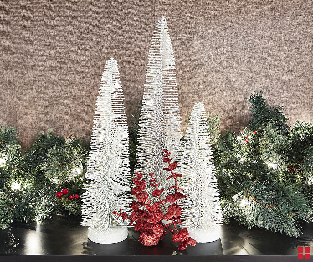 Three small bottle brush trees spray painted white.