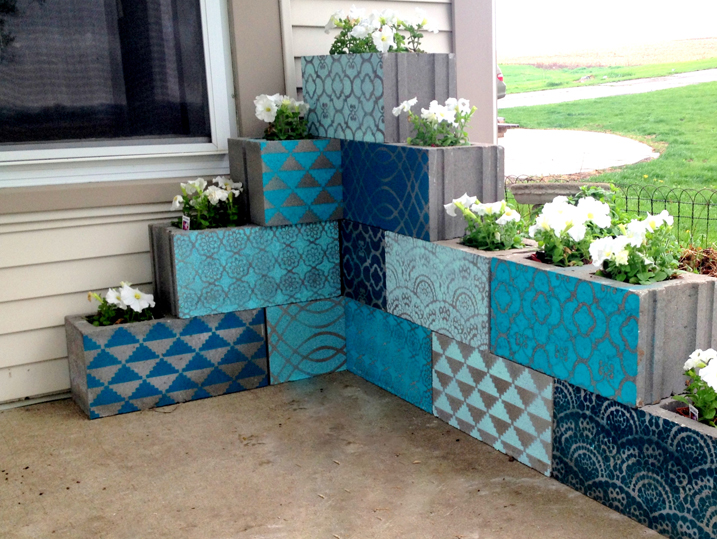 Painted cinderblock planters arranged on a patio.