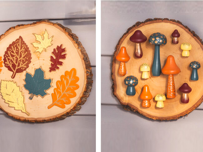On the left is a birch round featuring painted wooden leaves. On the right is a birch round featuring painted wooden mushrooms. 