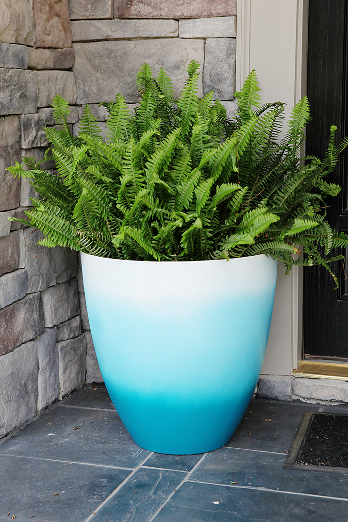 Large blue and white ombre painted planter on a front porch. 