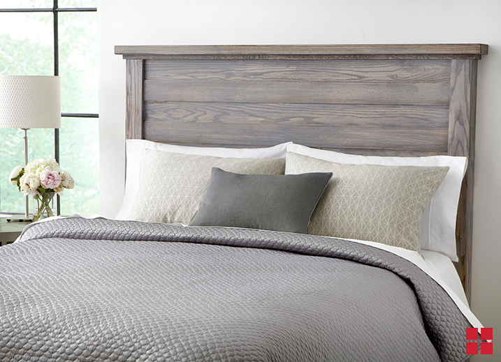 Wood stained headboard behind a bed. 