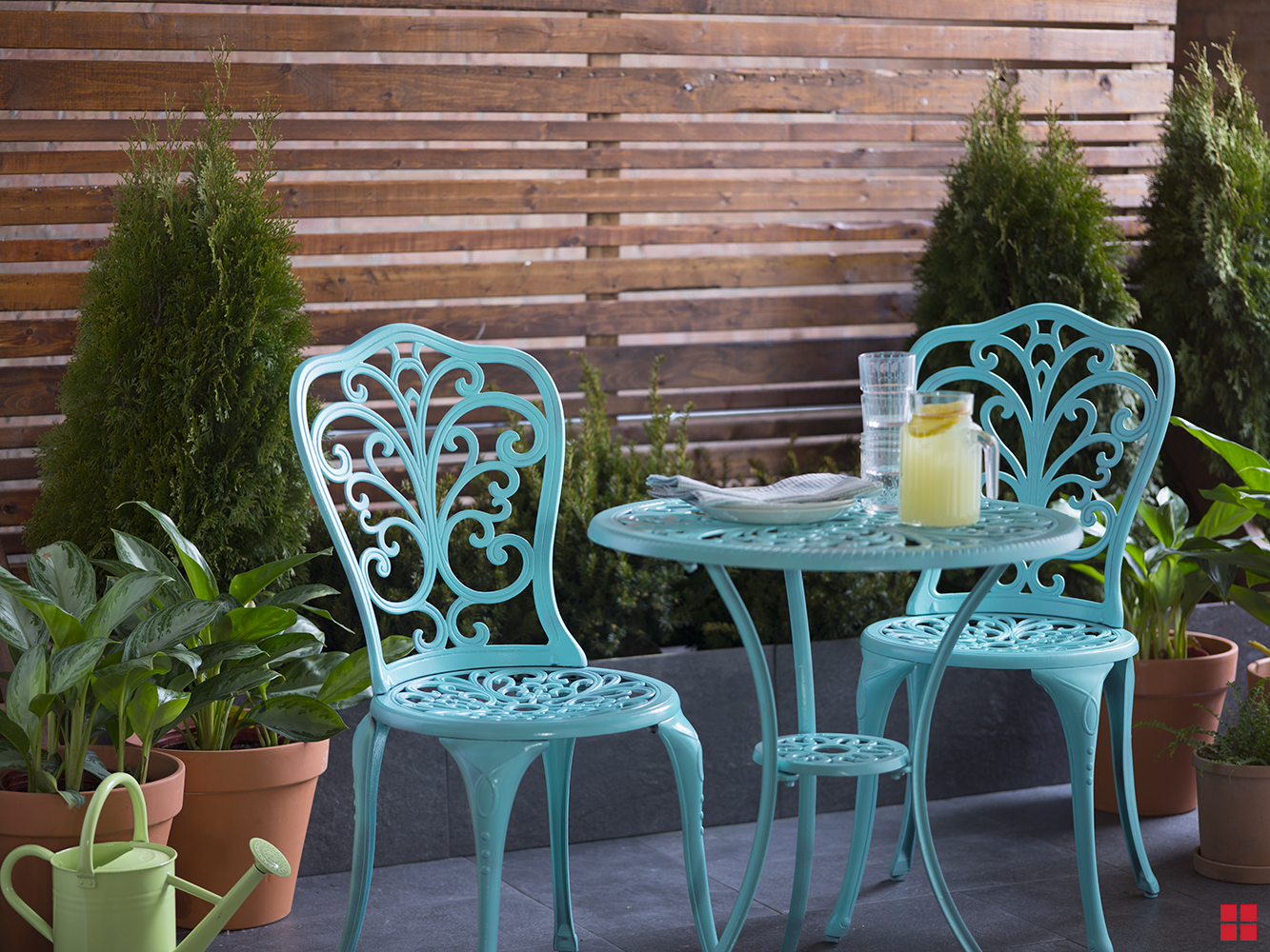 Blue bistro table and two chairs on a patio.