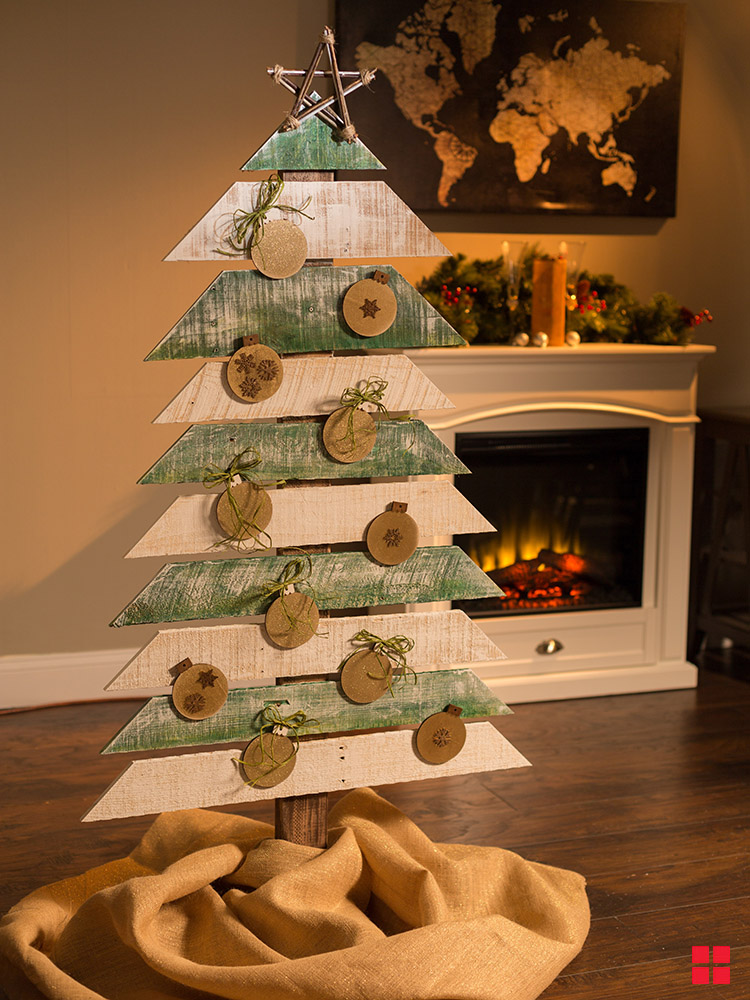 Rustic wood Christmas tree painted green and white with gold ornaments.