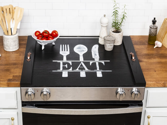 Black noodle board with the word “eat” painted on it.