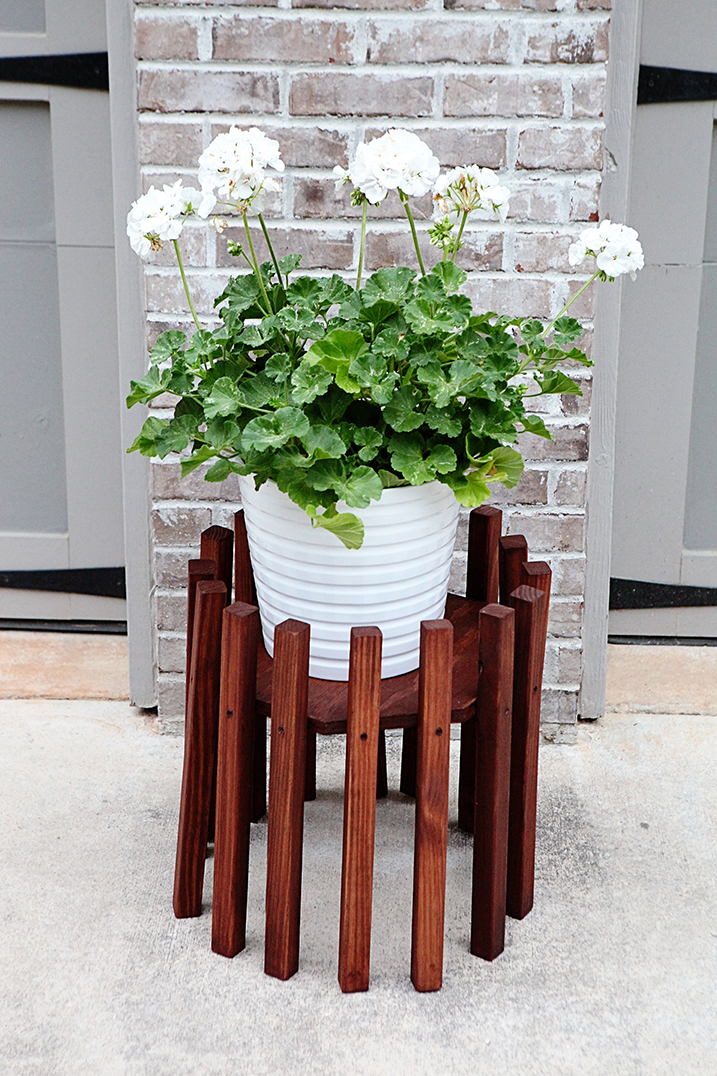 Dark stained wood pot stand made of several  pieces of plywood